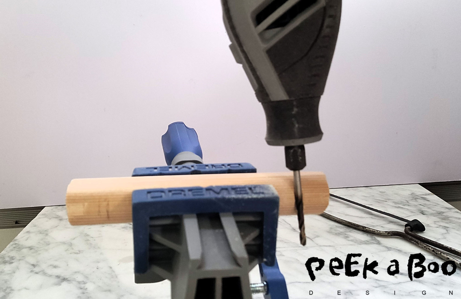 Place the wooden stik in your vise and drill half through to make the grooves..
