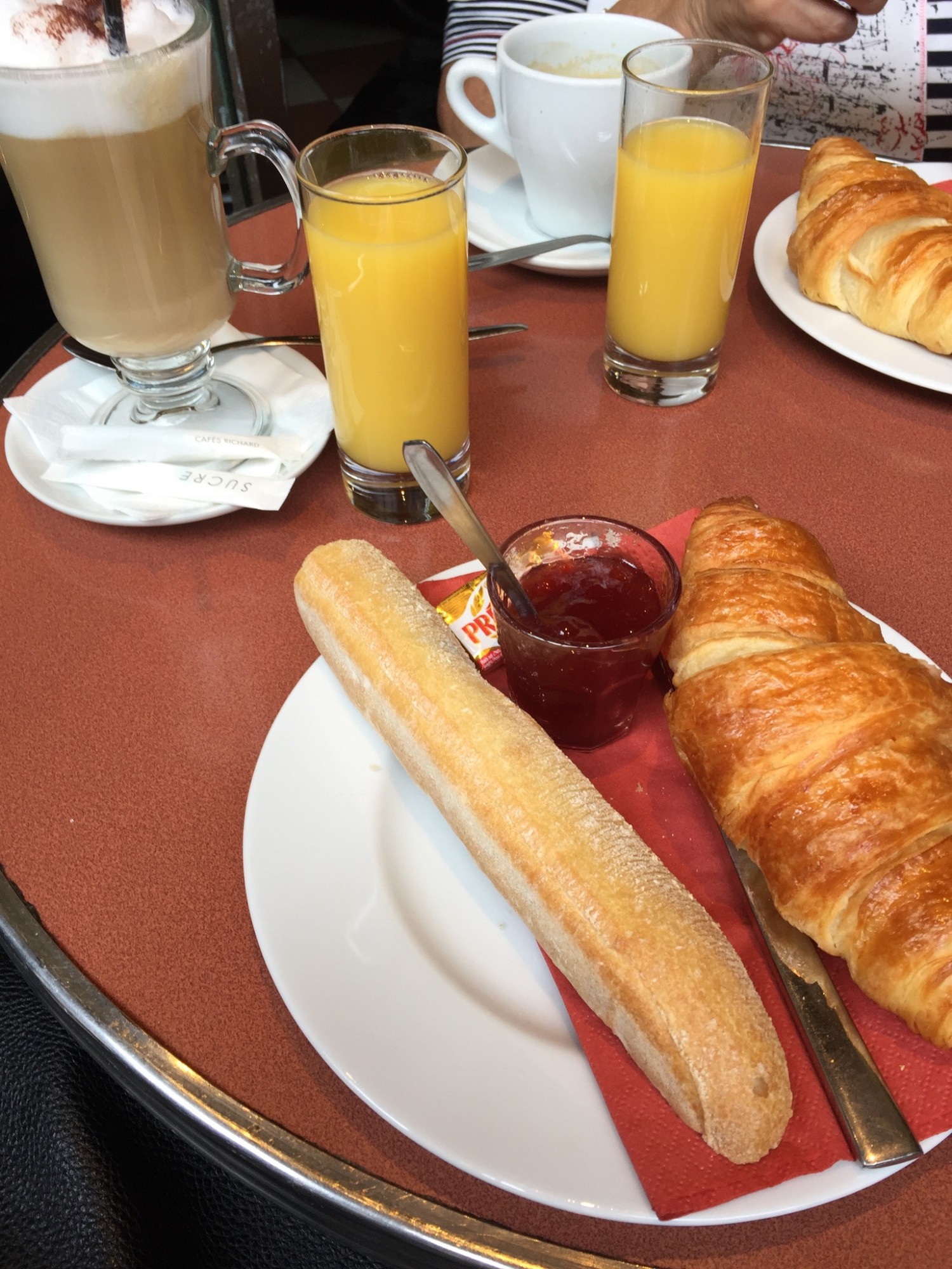Klassisk fransk morgenmad med kaffe, juice, baguette og croissant