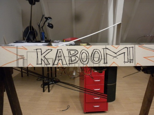 Fase 3 med den simple og tomme baggrundstegning (fortolkning af arkitektonen) samt udviklingen af bombens "historie" i forgrundet med "KABOOM!".