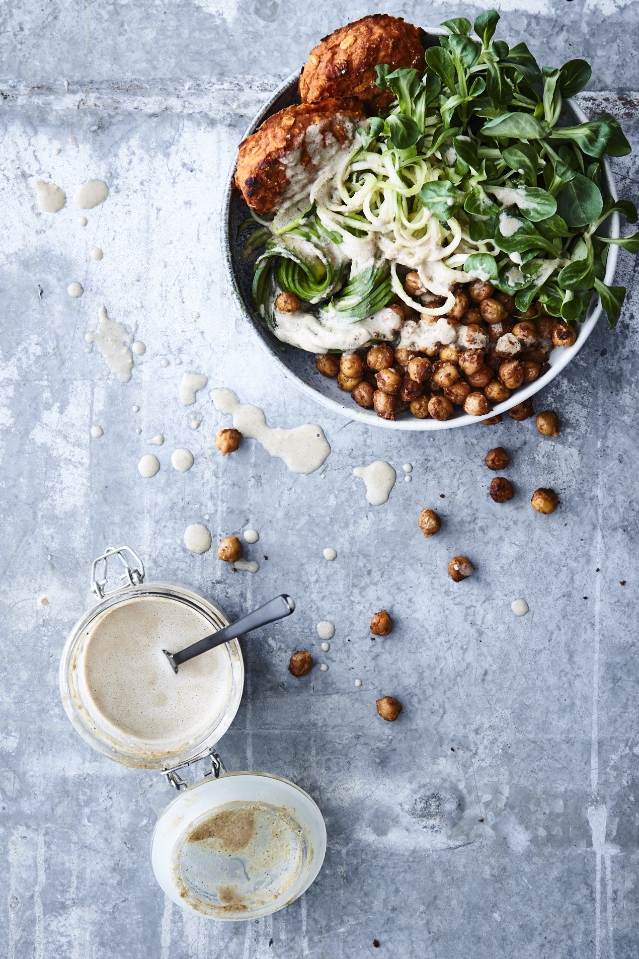 Buddha bowl with sweet potato patties, spicy chickpeas and tahini dressing