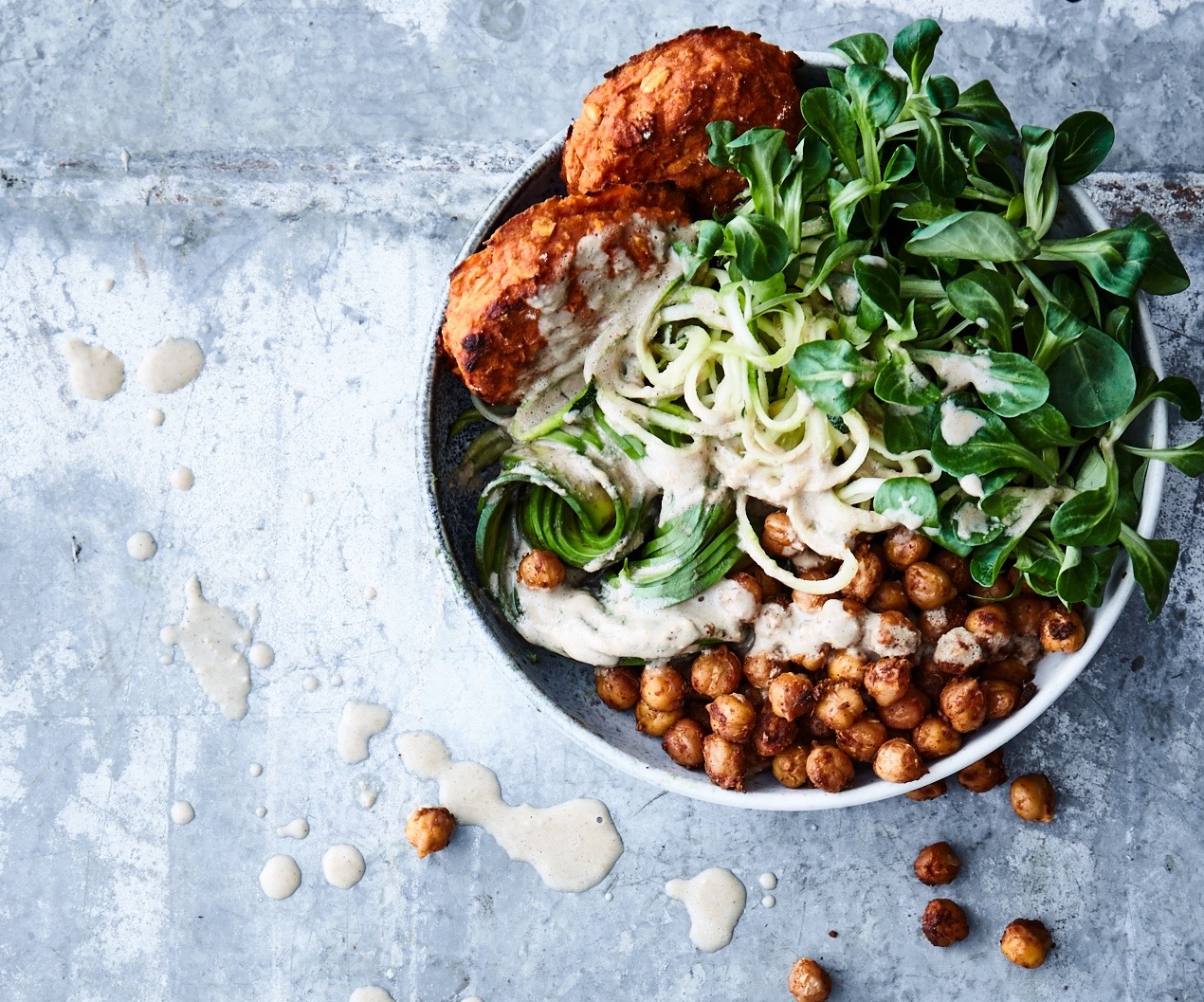 Buddha bowl with sweet potato patties, spicy chickpeas and tahini dressing